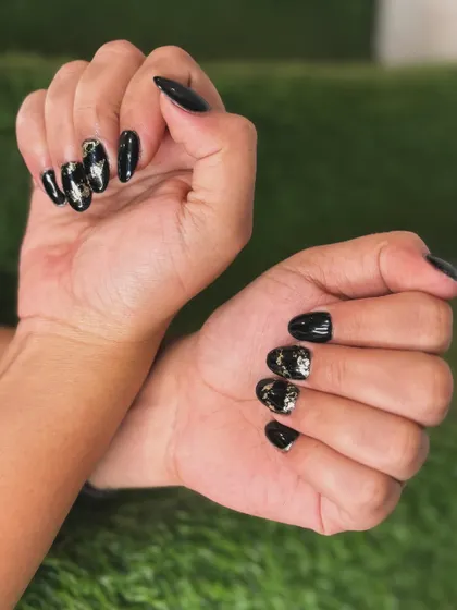 For a touch of drama, I created this look using a glossy black gel polish on almond-shaped nails. The accent nails feature a shattered gold and silver foil design for an edgy yet glamorous effect.