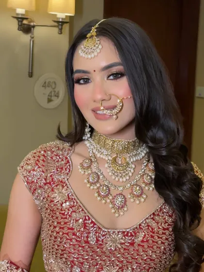 A beautiful close-up of this bride's wedding day makeup. We went for a classic look with softly smoked-out eyes, radiant skin, and a gentle pink lip that perfectly complemented her red lehenga.