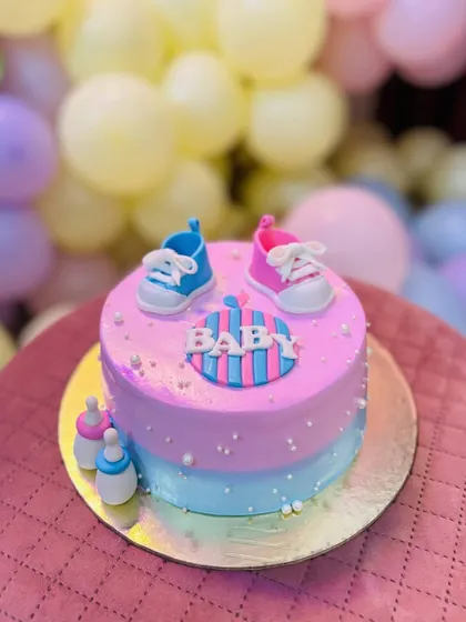 He or she, what will the baby be? This pink and blue baby shower cake with tiny fondant shoes and bottles is the sweetest way to celebrate a new arrival.
