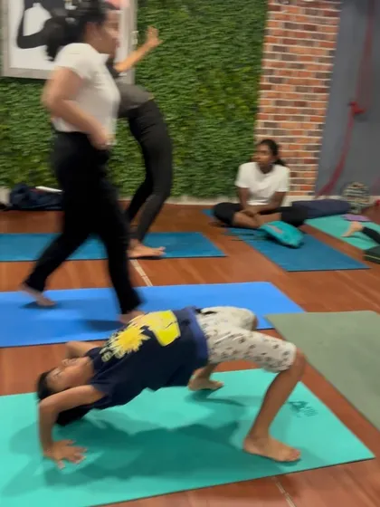 Even our youngest yogis can build amazing strength. Here a student holds a strong wheel pose.