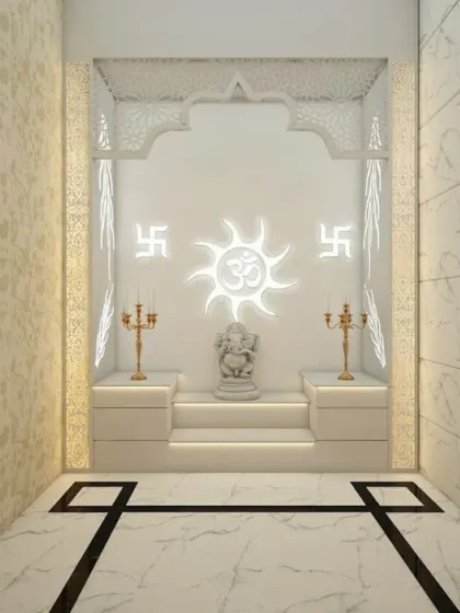 A pristine and peaceful pooja room designed in all-white with clean, geometric lines. The central focus is a backlit panel with Om and Swastik symbols, creating a serene glow around the Ganesha idol placed on a stepped platform.