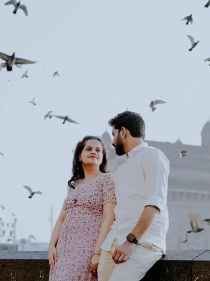 A stunning shot of the couple at the Gateway of India, surrounded by a flock of pigeons in flight, creating a magical and iconic Mumbai moment.
