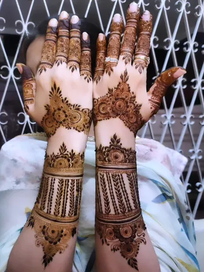 A classic design for Eid, featuring bracelet-like bands on the wrist and detailed patterns on the hands.