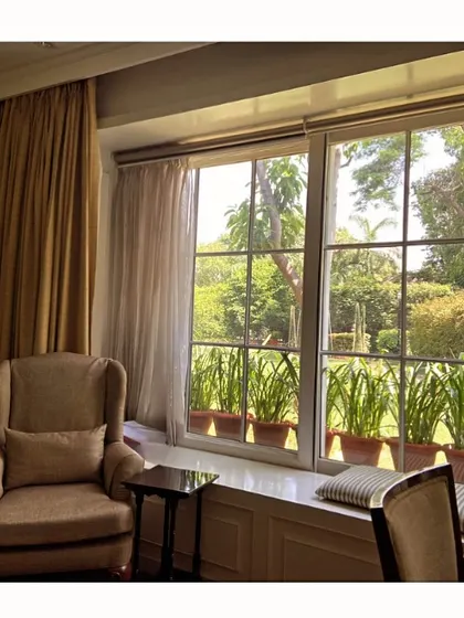 A detail of the biophilic design in the executive sitting area. The large windows not only provide a view but also feature a deep sill with potted plants, actively bringing greenery into the indoor environment and enhancing the connection to nature.