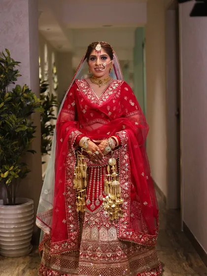 A classic, full-length portrait of the bride in her red wedding lehenga.