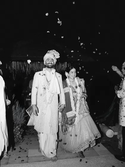 Rishi and Krishna's joyful exit, showered with petals. This black and white photo captures the energy and happiness of the moment in a classic, timeless way.