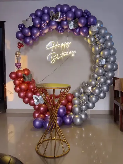 A three-toned balloon ring with purple, red, and silver sections, accented with butterfly details.
