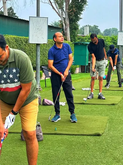 A close up of a line of golfers, each focused on their technique. This highlights the dedicated practice that happens here daily.