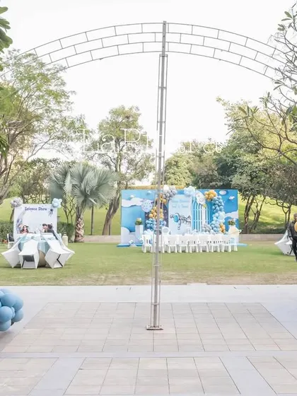 A wide view of the outdoor space-themed party setup, showing the various decorative elements and how they transform a green lawn into a cosmic playground.