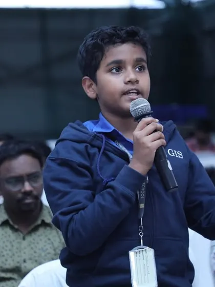 A young student engages with the audience, asking a thought-provoking question. This captures our goal of fostering curiosity and building the confidence to lead conversations.