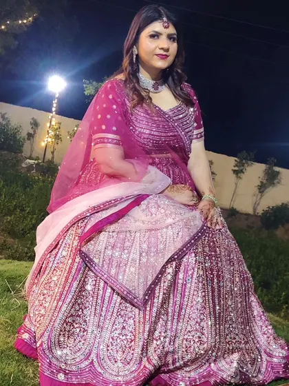 A client looking regal in a heavily embroidered magenta lehenga. This is a fantastic choice for a close family member's wedding.