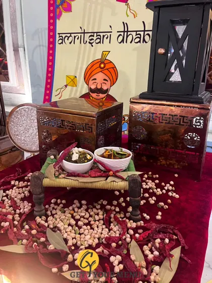 For a rustic and authentic feel, we can create themed counters like this Amritsari Dhaba setup, complete with a miniature charpai and traditional Punjabi dishes.