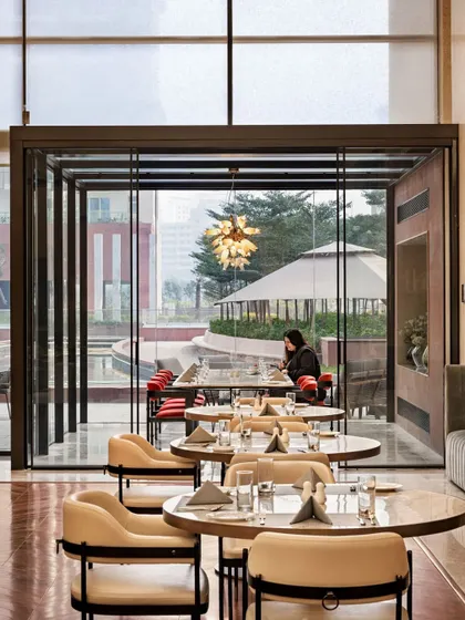 A glass-encased private dining area at the Elevate Clubhouse offers an exclusive experience while overlooking the outdoor landscape. This feature provides privacy without sacrificing the feeling of openness.