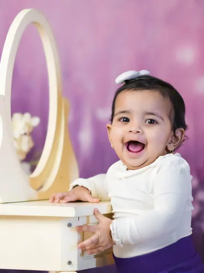 A happy baby girl looking in the mirror. These simple, interactive moments often create the most beautiful and genuine smiles.