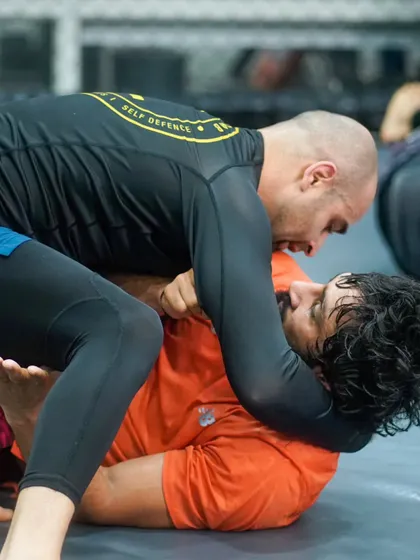 Two grapplers locked in a tight battle for position. This is the chess match of Jiu Jitsu, where every move and counter-move matters.