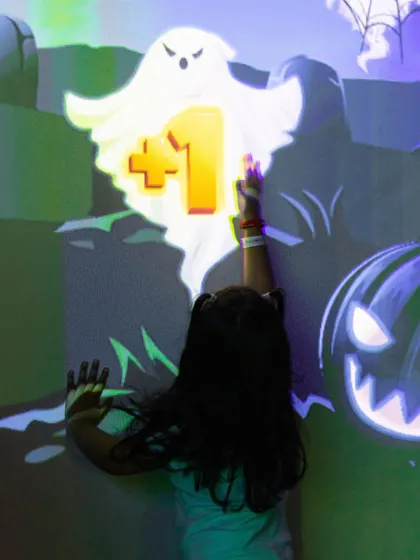 Playing a ghost-hunting game on our giant interactive wall. It's a fun and active way to play a video game.