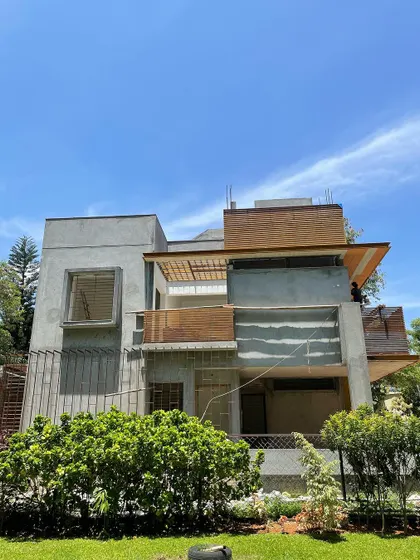 The house seen from the park, with its facade of concrete and wood-clad balconies.