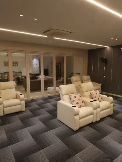 A view from the back of the home theater, showing the tiered seating arrangement and the soft profile lighting that sets the perfect ambiance.