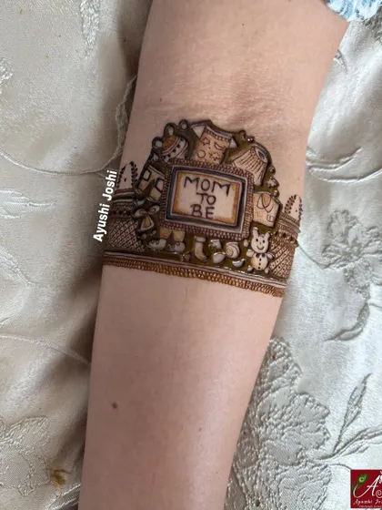 A startup of the "Mom to be" arm band, showing the cute frame made of baby clothes, toys, and teddy bears.
