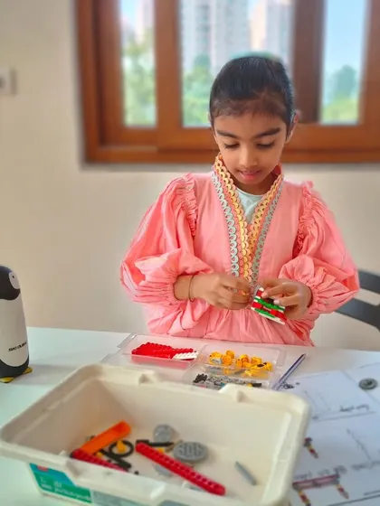 A student at our Whitefield summer camp is focused on her build, demonstrating the quiet concentration that comes with engaging, hands-on work.