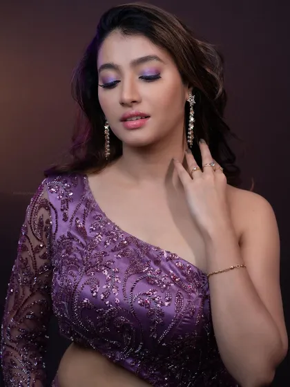 A close-up portrait focusing on the model's makeup and the sparkle of the dress.