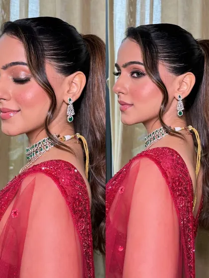 A stunning red shimmery lehenga for a cocktail night. The makeup features a sharp winged liner with crystal accents, paired with a sleek high ponytail for a chic and modern vibe.