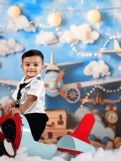 Aye aye, Captain. This little pilot gives a confident smile as he sits in his plane, ready for takeoff in our sky-themed studio.