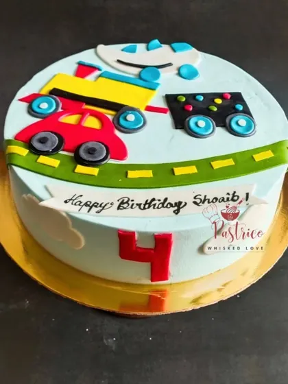 A cute and colourful car-themed cake for a 4th birthday, featuring a road with little edible cars driving along.