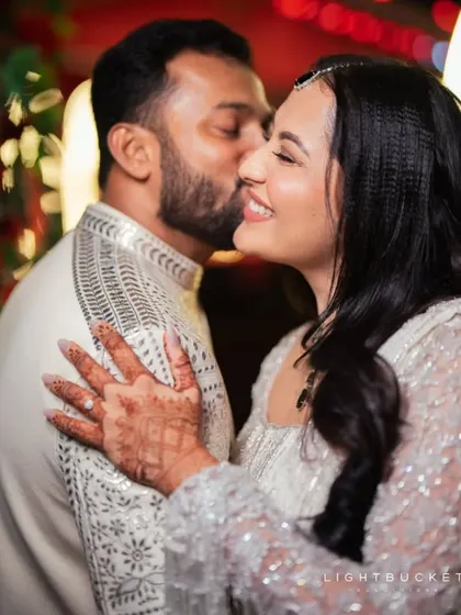 A sweet kiss on the cheek, a moment of pure affection captured between the couple.