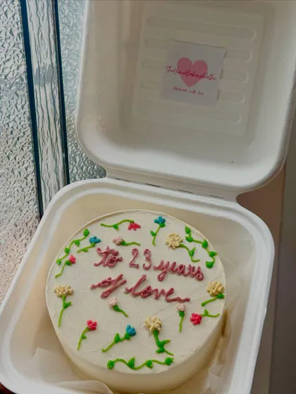 A floral bento cake celebrating 23 years of love. The tiny, hand-piped flowers add a delicate and personal touch to this anniversary cake.