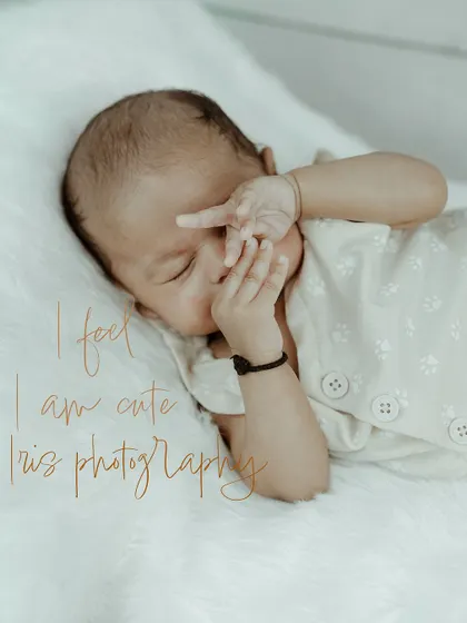 A sweet and funny newborn photo of a sleeping baby with a hand covering their face. This candid moment captures the unique and unpredictable charm of newborn photography.