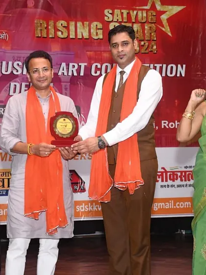 A proud moment of recognition. A participant receives an award on stage, celebrating his hard work and talent. We believe in acknowledging and encouraging every artist's journey.