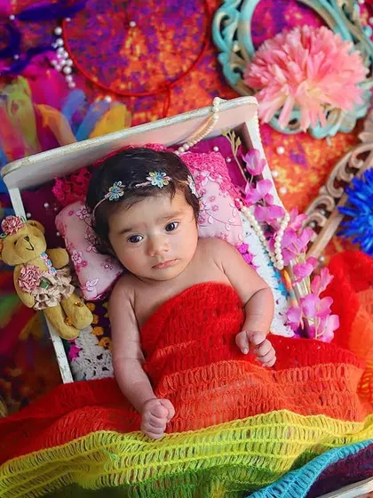 "Mohe rang do laal..." 🌈 A colorful and creative setup for a baby's first Holi photoshoot. This little one is wrapped in a rainbow of colors, looking so sweet and curious.