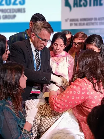 A live hands-on demonstration during a training session. Participants gather closely to observe and learn the precise techniques for injectable treatments, fostering a collaborative and intensive learning environment.