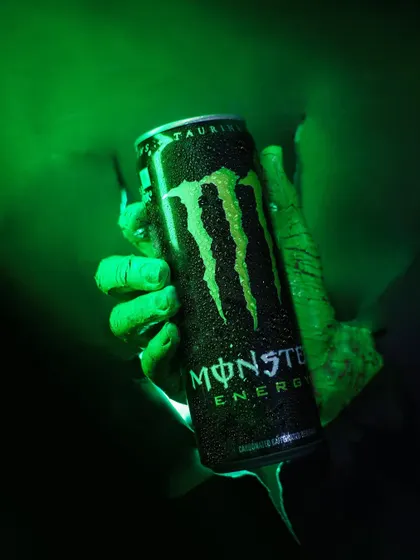 Unleash the beast energy. A close-up of the final shot, showing the Monster can bursting through the background with dramatic green lighting and water droplets for effect.