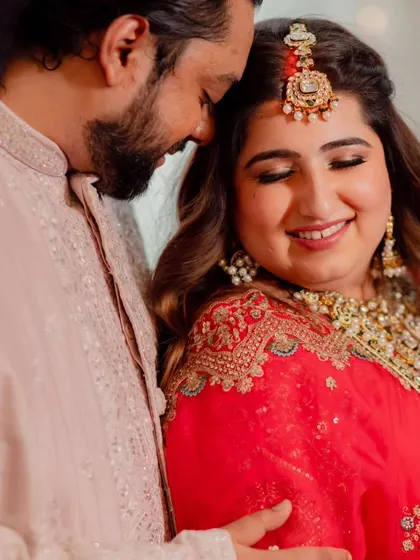 A close-up of the bride's happy expression. Her makeup features a subtle smokey eye and a nude lip, letting her natural beauty shine through.