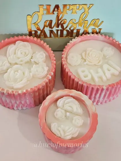 This set of three custom candles was made for a Rakshabandhan order. The pink marbled jars are filled with soy wax and topped with delicate wax roses, with one personalized for 'BHAI'.