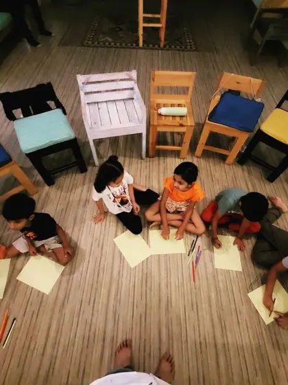 An overhead view of our 'creation station'. Children gather on the floor, completely focused on their artwork. This quiet, concentrated time is a beautiful contrast to the high-energy storytelling that precedes it.