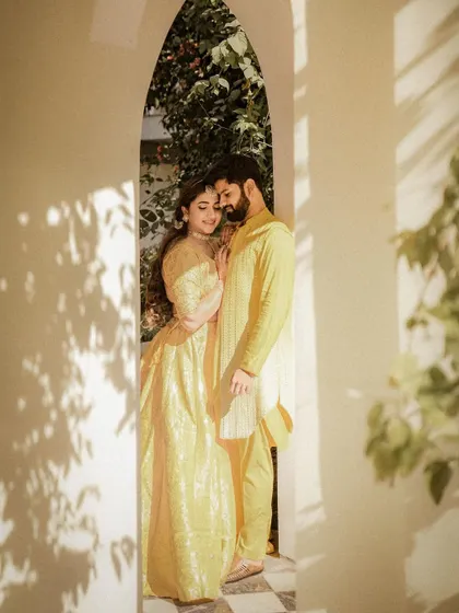 An intimate portrait of the couple framed by an archway, the soft light and their close embrace creating a deeply romantic mood.
