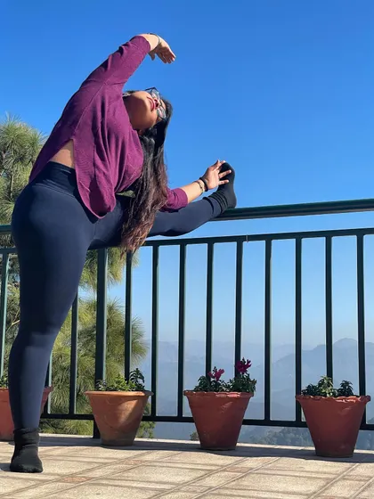 While traveling, a little stretch is a must to relieve stiffness. Here I am using a railing for a standing split variation, enjoying the fresh mountain air and the beautiful view.