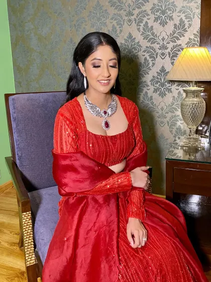 A soft and happy moment. Her makeup is glowing and her eyes are beautifully enhanced, complementing the statement ruby and diamond necklace.