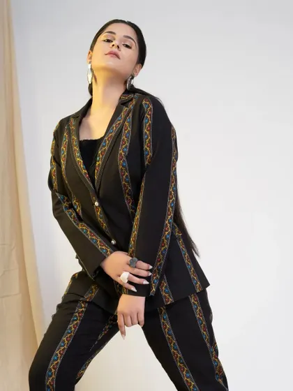 A strong, angled shot of the black pantsuit, highlighting the sharp tailoring and the model's commanding presence. This type of image is great for conveying a brand's bold identity.