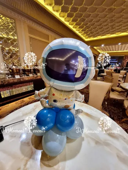 An astronaut foil balloon centerpiece, perfect for adding a touch of cosmic fun to the tables at a space-themed party.