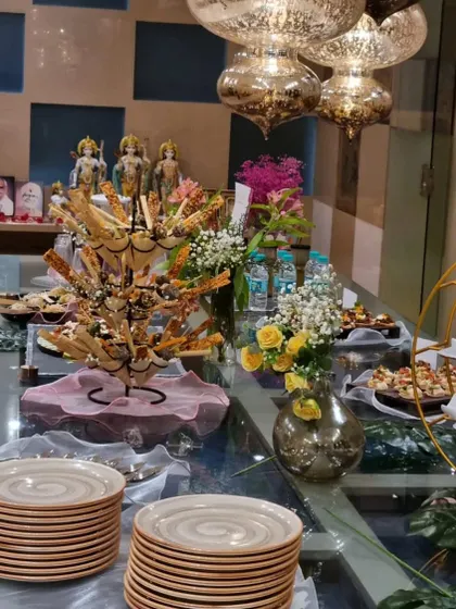 A visual representation of our food cravings. This high tea setup features breadsticks on a decorative stand, surrounded by various appetizers and desserts under elegant chandeliers.