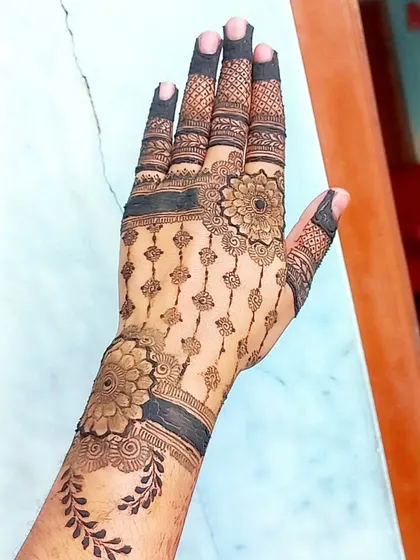 A beautiful and intricate design with a 'jaali' pattern on the fingers and a floral cuff.