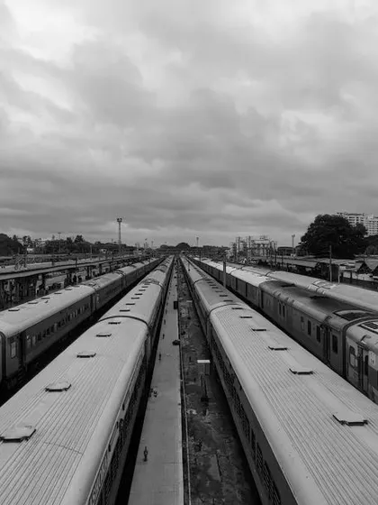A black and white photograph of multiple railway tracks and trains, evoking a sense of travel and endless possibilities.