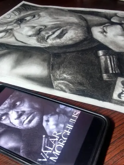 My completed charcoal sketch of Tyrion Lannister, shown next to the digital reference image on my phone. This gives an idea of how I work from photos to create my art.