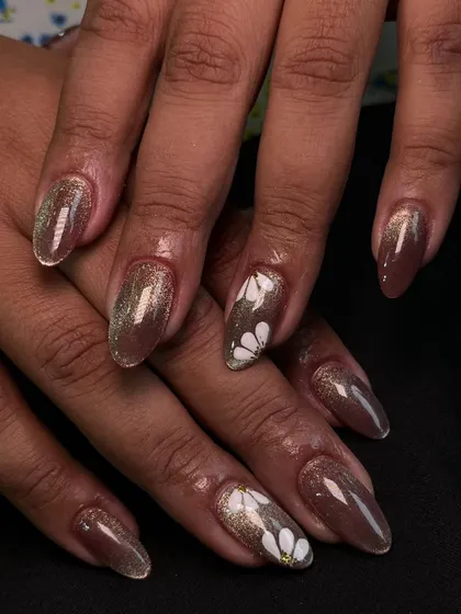 Here, I used a shimmery brown cat-eye gel polish as the base. On top, I hand-painted simple white daisies to create a beautiful contrast between the sparkling background and the soft floral art.