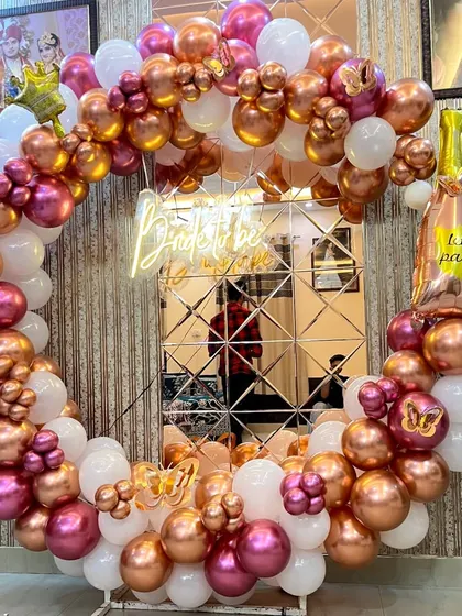 A close-up of the detailed balloon work on the circular 'Bride to be' frame, featuring a champagne bottle foil balloon for a fun touch.