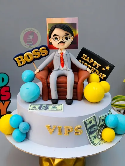 A fun cake for a boss, featuring a custom figurine, money details, and a "BOSS" sign.